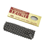 Izumi ES410 JB Track Chain with 116 links, black with gold joints, 1/2" x 1/8" bike chain component, shown in close-up.