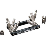 Schwalbe workshop multi-tool with hex keys, Torx T25, screwdriver, and valve tool for bike repairs, shown with various tools.