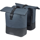 Basil Cove double pannier bag in water-repellent fabric attached to a bicycle for commuting, with reflective details and adjustable straps.