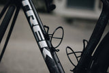 Elite Leggero carbon fibre bottle cage, lightweight Italian cycling accessory, shown mounted on a bicycle frame.