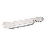 Park Tool HCW-16.3 chain whip and 15mm pedal wrench for bike maintenance, shown in a workshop setting with tools and bike parts.