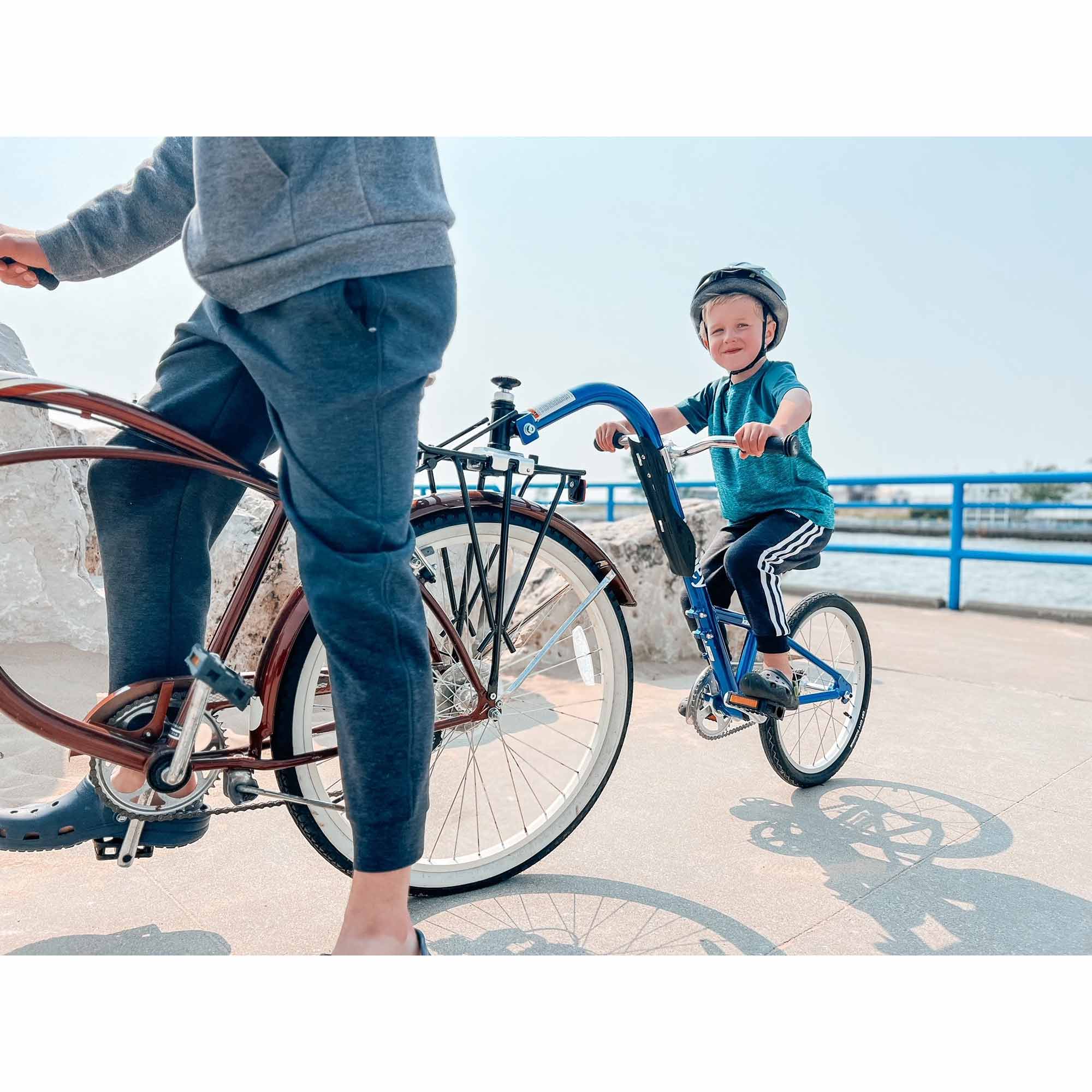 Burley Kazoo kids bike trailer with adjustable handlebar and safety flag, designed for cycling with children and easy attachment.