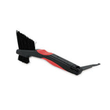 Zefal Clean Brush 3-in-1 bike cleaning tool for chains, freewheels, and derailleurs, shown in a workshop setting.