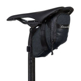 Lizard Skins Micro Cache Saddle Bag in Jet Black attached to a bike saddle, lightweight bike storage accessory for cycling gear.
