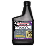 Finish Line Shock Oil 10 wt 16 oz bottle for bike suspension forks, shown in workshop setting with labeled packaging.