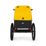 Burley Bee bike trailer for single child with safety harness and weather cover, outdoor accessory for secure cycling with kids.