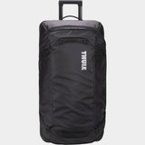 Black Thule Chasm Rolling Duffel Bag showing durable weather-resistant fabric and sturdy wheels for travel accessories.