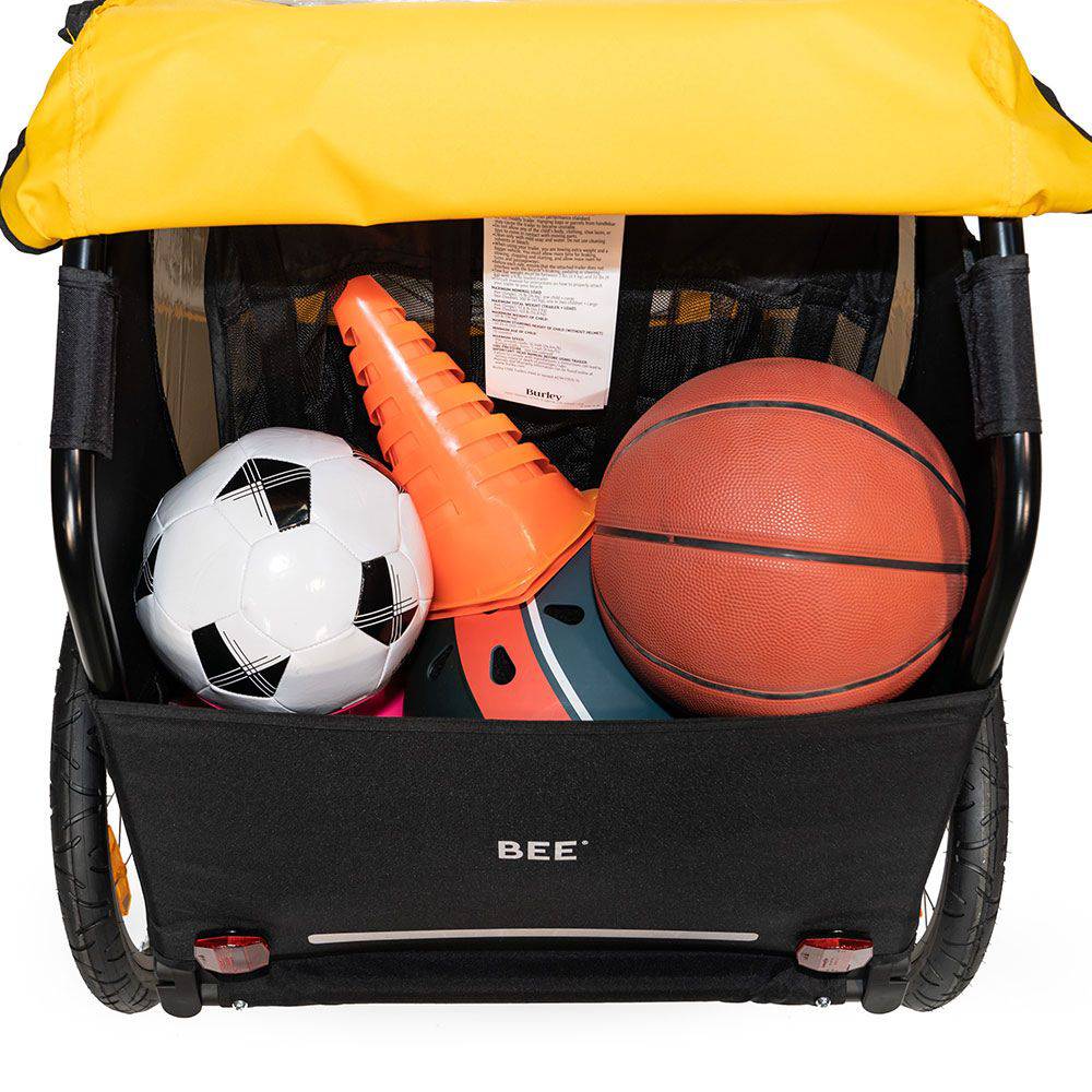 Burley Bee bike trailer for kids with 5-point harness, storage space, and durable frame, designed for safe family cycling adventures.