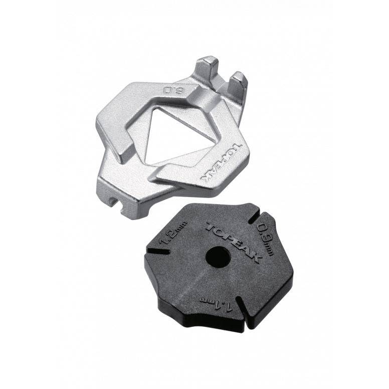 Topeak Duo Spoke Wrench tool for bike wheel spoke adjustments, shown in a workshop setting with the wrench in hand.