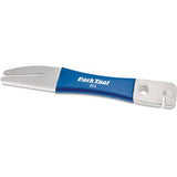 Park Tool DT-2 rotor truing fork for precise disc brake rotor adjustment in workshop setting, with metal prongs and ergonomic handle.
