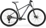 Merida Big Nine 20 aluminium mountain bike with Shimano CUES U2000 components and inboard disc brakes, positioned on trail.