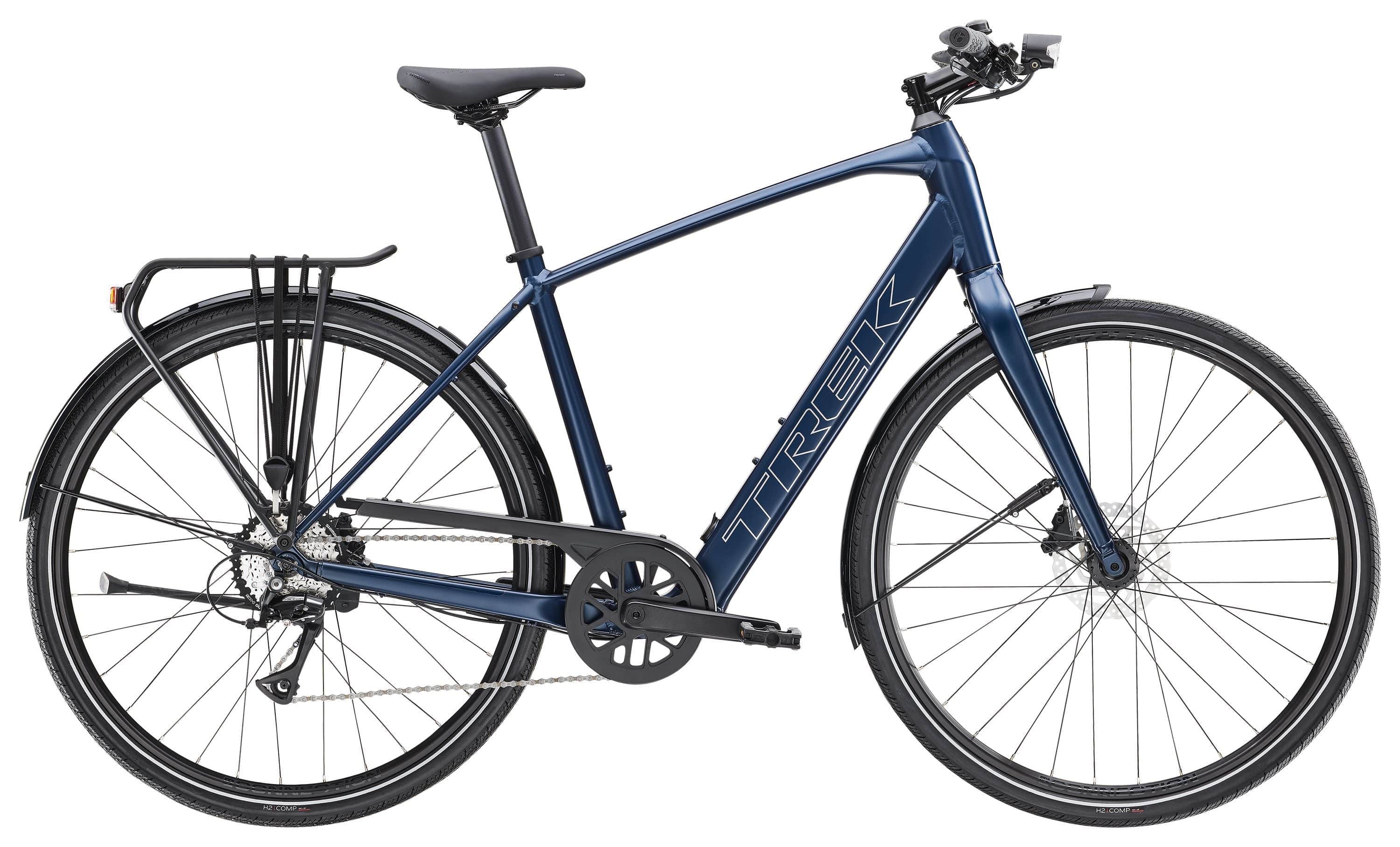 Trek FX+ 2 LT e-hybrid commuter bike with pedal assist, rear rack, and disc brakes, shown in a city street setting.