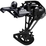 Shimano Deore XT RD-M8100 12-speed MTB rear derailleur with Shadow+ SGS design, mounted on a mountain bike drivetrain.