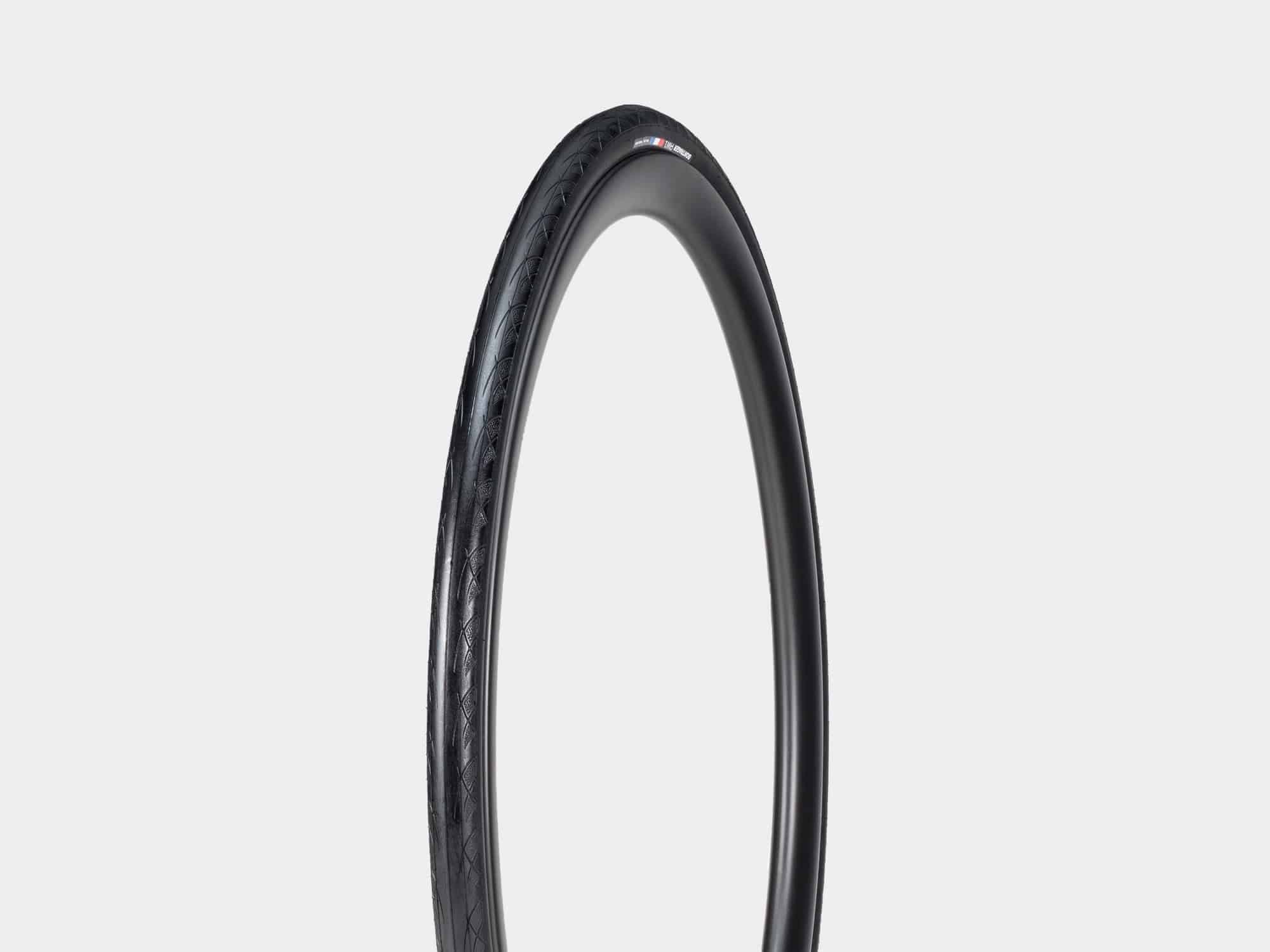 Bontrager AW1 Hard-Case Road Tire with Triple Flat Protection showing the black tire and tread pattern for durability and speed.