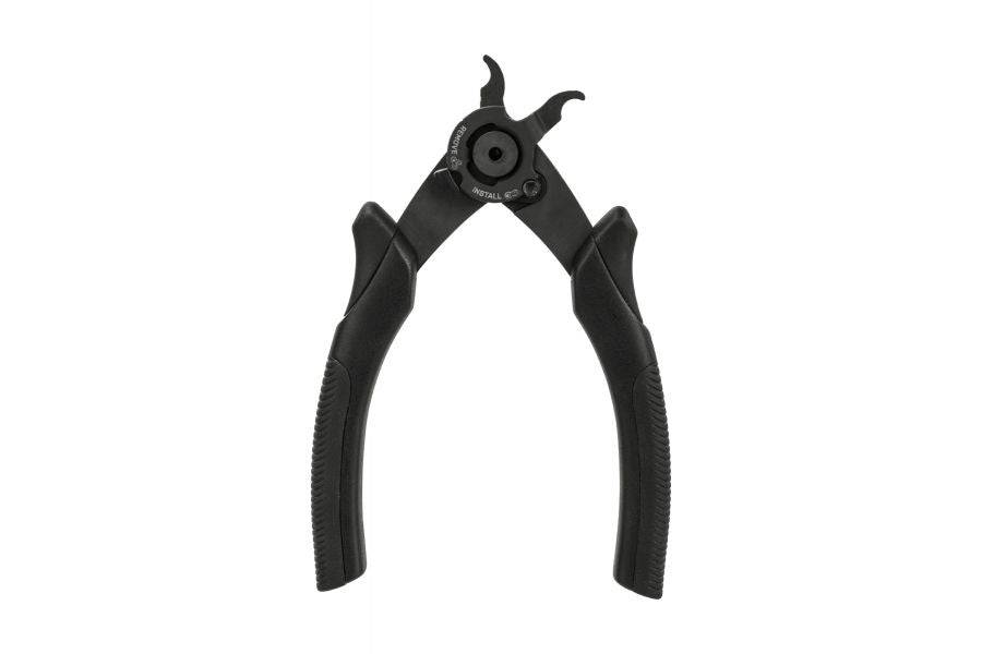 Topeak Power Link Pro Master Link Tool with padded grip for bike chains, black, used in bike workshop, close-up of tool in hand