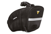 Topeak Aero Wedge Medium black strap mount bike saddle bag attached to cycling saddle for storage.