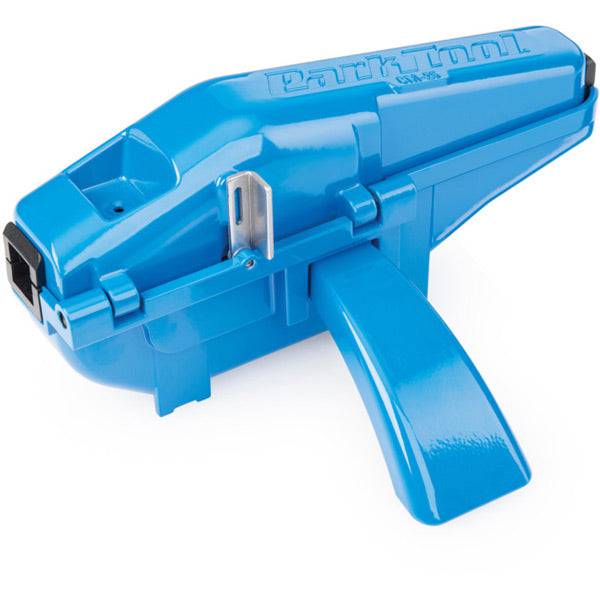 Park Tool CM-25 professional bike chain scrubber with replaceable brush and sponge cartridge, used in workshop for cleaning bike chains.
