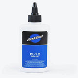 Park Tool CL-1.2 synthetic blend bike chain lube in a workshop setting, showcasing the eco-friendly lubricant bottle.