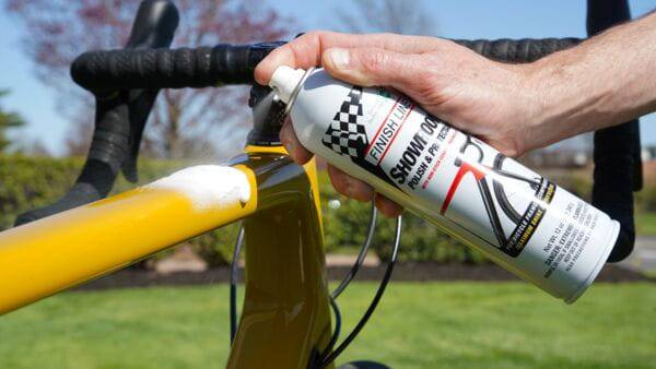 Finish Line Showroom Polish Ceramic Tech aerosol bike cleaner and protector in a workshop setting, box of 6 bottles.