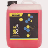 Gtechniq Bike Wash 5L biodegradable pH-neutral cleaner for bikes, shown in a workshop setting with cleaning supplies and bike parts