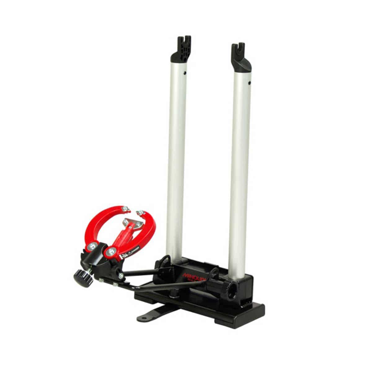 Minoura FT-1 Pro portable foldable wheel truing stand for road and mountain bike wheels up to 29 inches, in a workshop setting.