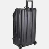 Black Thule Chasm Rolling Duffel Bag showing durable weather-resistant exterior and sturdy wheels for travel accessories.