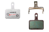 SwissStop Disc 15 brake pads for Shimano M5, T6, and M3 silver disc brakes, shown installed on bicycle wheel.