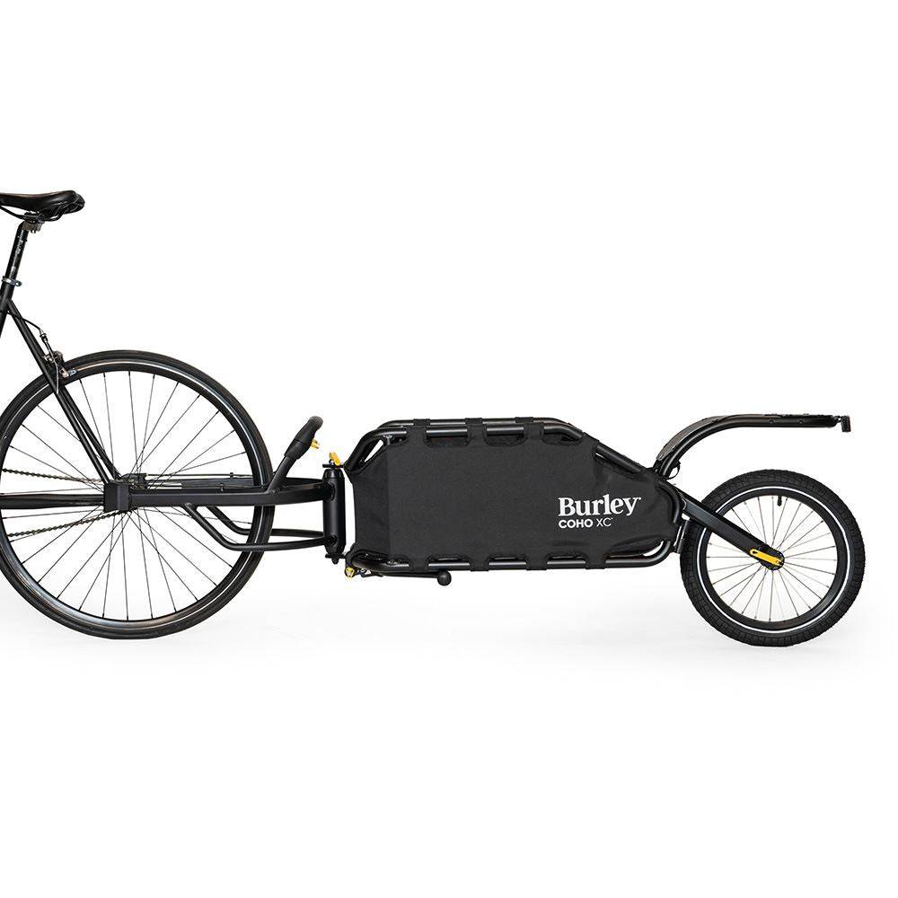 Burley Coho XC cargo bike trailer with suspension and quick release lever, shown attached to a bicycle for hauling gear.