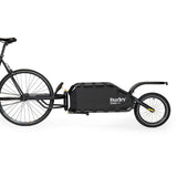Burley Coho XC cargo bike trailer with suspension and quick release lever, shown attached to a bicycle for hauling gear.