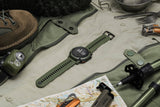 Coros Nomad outdoor GPS watch with green strap, showing adventure journal and multiple sport modes on digital display.