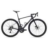 Liv Devote Advanced 2 2025 gravel bike with disc brakes, shown on mixed terrain, featuring a lightweight frame and rugged tires.