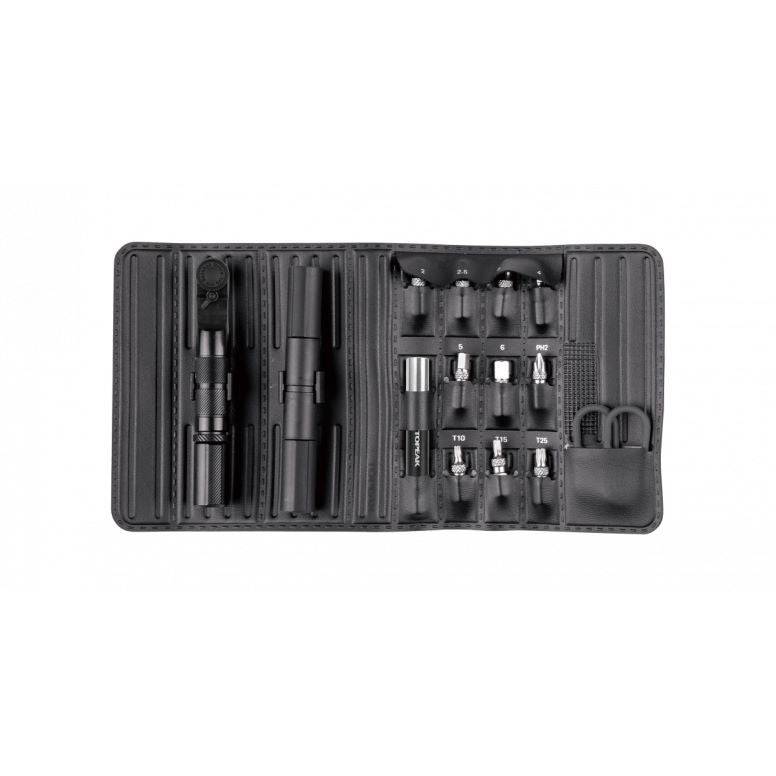 Topeak Ratchet N Roll Elite black compact bike repair toolkit with CO2 inflator on workshop workbench, organized with tools and accessories.