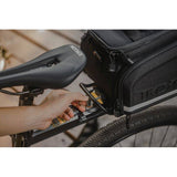 Topeak MTX Trunklock in black securing MTX 2.0 Trunkbag with spare key on a bicycle.