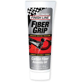 Finish Line Fiber Grip Carbon Fiber Assembly Gel for secure bike component grip, shown in a workshop setting.