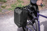 Madison Bags Roam 30L waterproof pannier bag with quick-release mount system, shown attached to a bicycle rack.