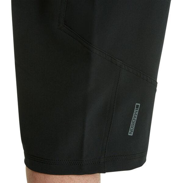 Madison Zenith men's mountain bike shorts with water-resistant coating and adjustable waist, shown in a natural outdoor setting.