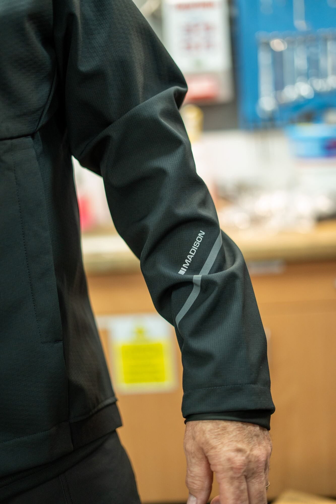 Madison DTE Workshop men's 3-layer softshell jacket for cycling and work, shown in black with a zipper front and adjustable cuffs.