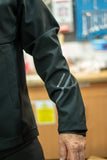 Madison DTE Workshop men's 3-layer softshell jacket for cycling and work, shown in black with a zipper front and adjustable cuffs.
