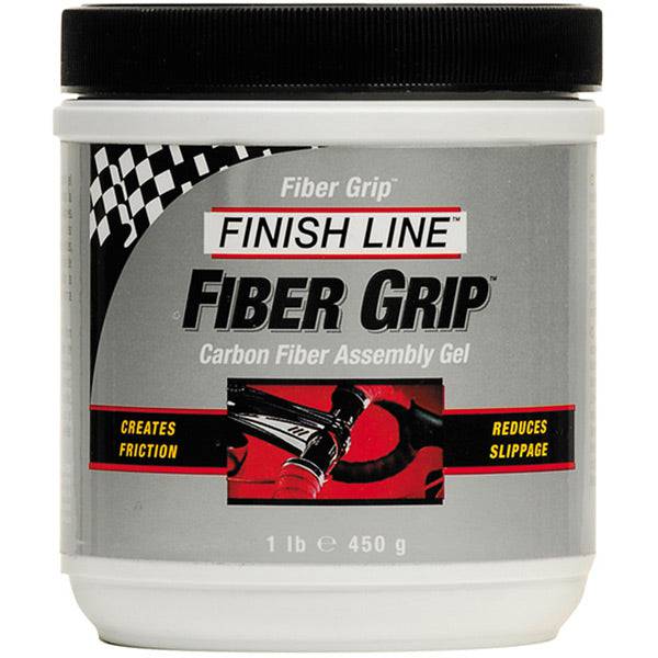 Finish Line Fiber Grip carbon fiber assembly gel tub for bike components, shown in a workshop setting.