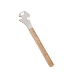 Lezyne Classic Pedal Rod 15mm wrench with bottle opener, used for bike pedal adjustment, shown in workshop setting.