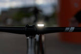 Knog Frog V3 rechargeable bike light set in denim blue with front and rear lights, compact and waterproof for cycling visibility.