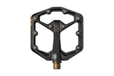 Crank Brothers Stamp 11 flat mountain biking pedal with adjustable pins, black metal body and red accents, close-up view