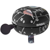 Basil Wanderlust Big Bicycle Bell 80mm in charcoal with bird print, bike safety accessory on a bicycle handlebar.
