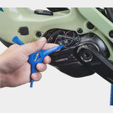 Park Tool EWS-2 electronic wire tool for Shimano Di2 and SRAM battery covers, shown in a workshop setting with the tool in hand.