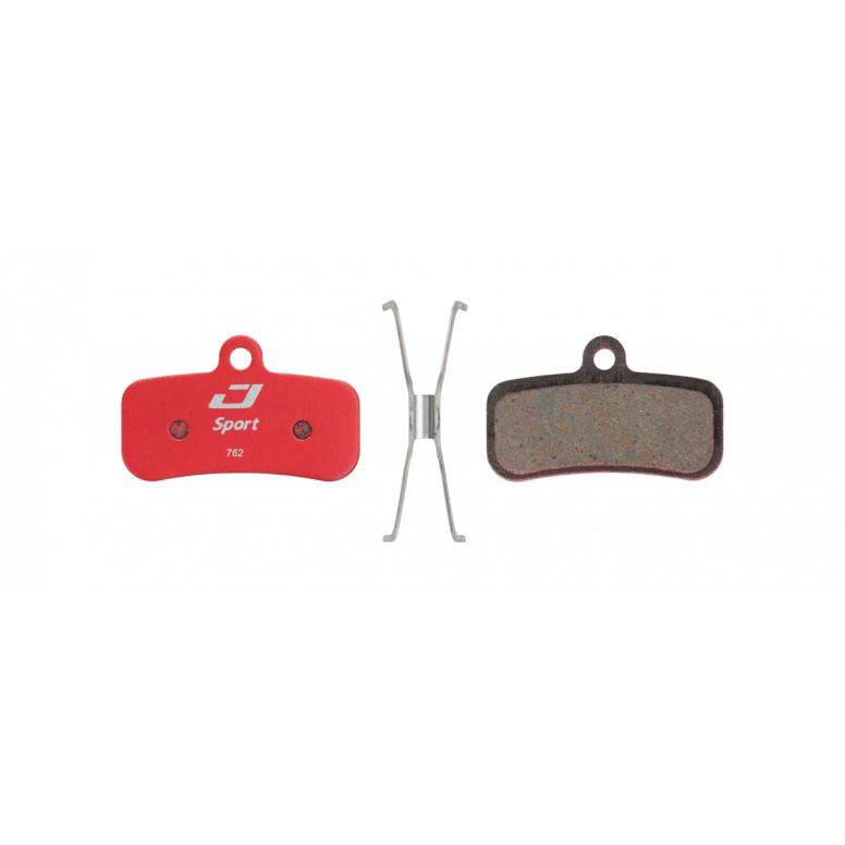 Jagwire Sport semi-metallic disc brake pads for Shimano and RideRever MTB bikes, shown with brake components and mounting hardware.