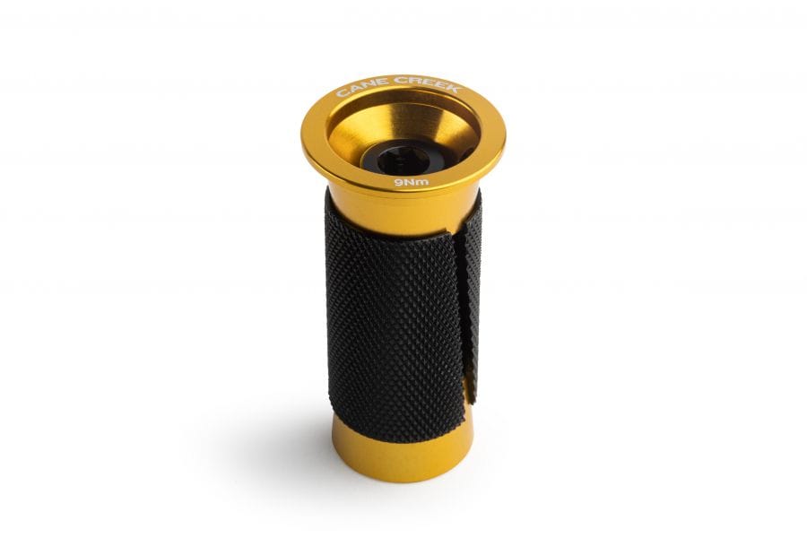 Cane Creek Ancora expander plug for carbon steerer tubes in black and gold, component for bicycle steering systems.