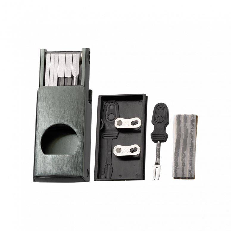 Crankbrothers F11 multi-tool in black with tyre plug and chain link holder for bike maintenance, shown in a workshop setting.