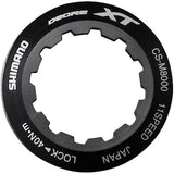 Shimano Spares CS-M8000 lock ring and spacer for cassette maintenance, close-up of components on a bike drivetrain.