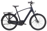 Trek District+ 1 2025 electric hybrid bike for urban commuting, shown in a city street setting with sleek frame and handlebars.