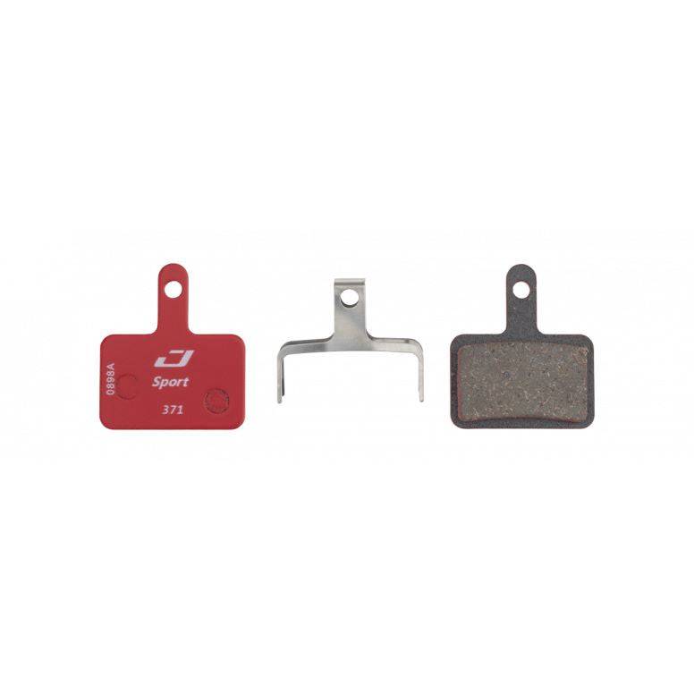 Jagwire Sport semi-metallic disc brake pads for Shimano and Promax systems, shown in red for high-performance bike braking.